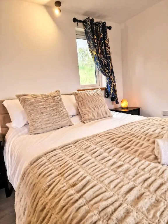 a bedroom with a large bed with a window at Kaoglen Buck Pod - Hot Tub - Dog Friendly in Blairgowrie