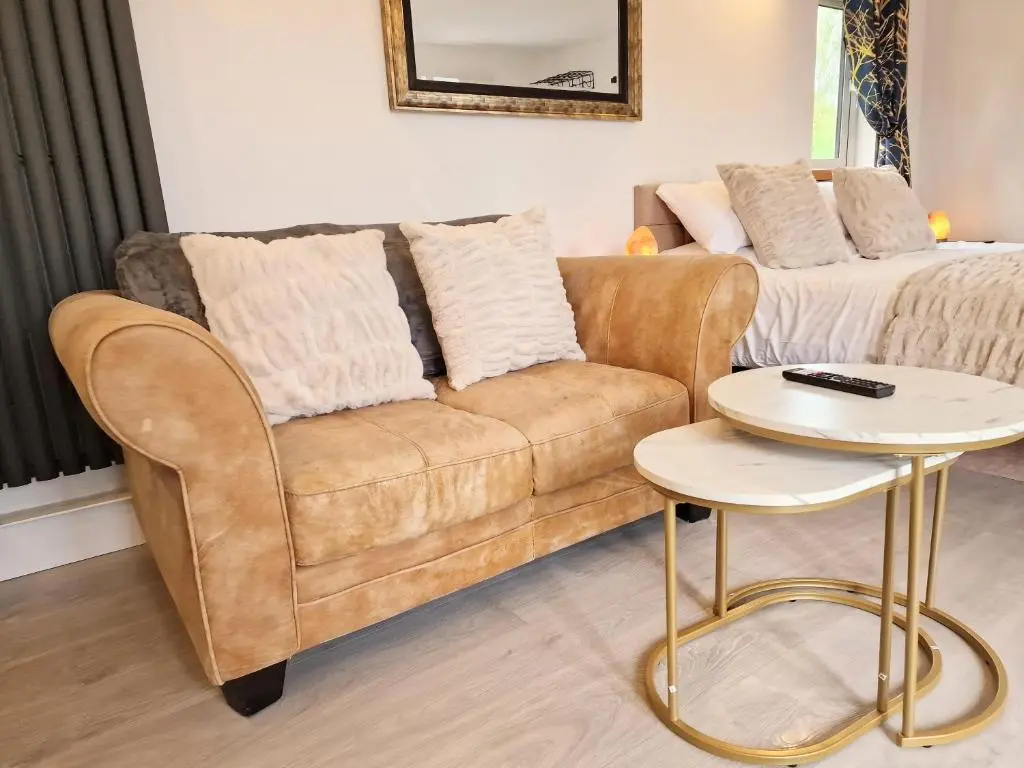a living room with a couch and a table at Kaoglen Fallow Pod - Luxury - Hot Tub - Pet Friendly in Blairgowrie