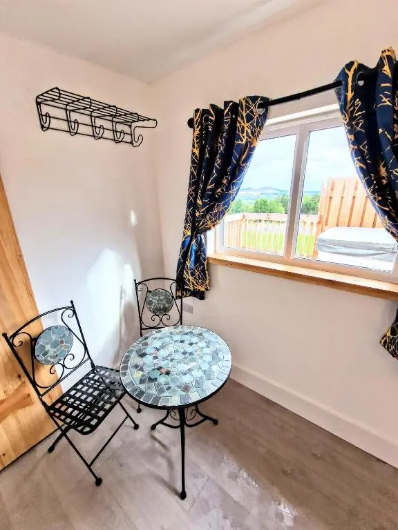 a room with two chairs and a table and a window at Kaoglen Fallow Pod - Luxury - Hot Tub - Pet Friendly in Blairgowrie