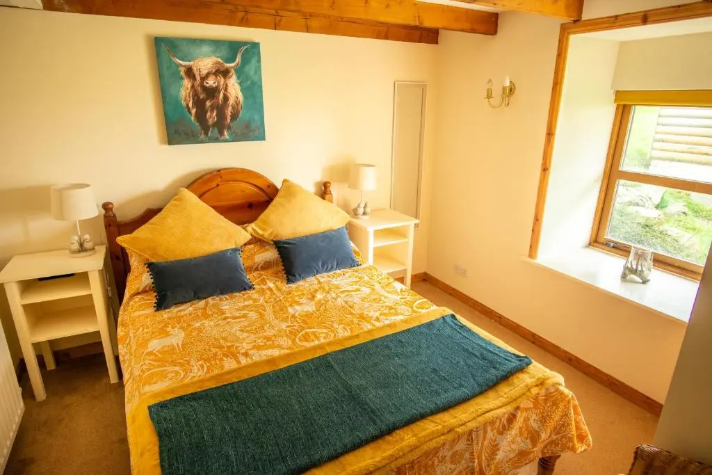 a bedroom with a bed and a window at The High Croft in Rogart