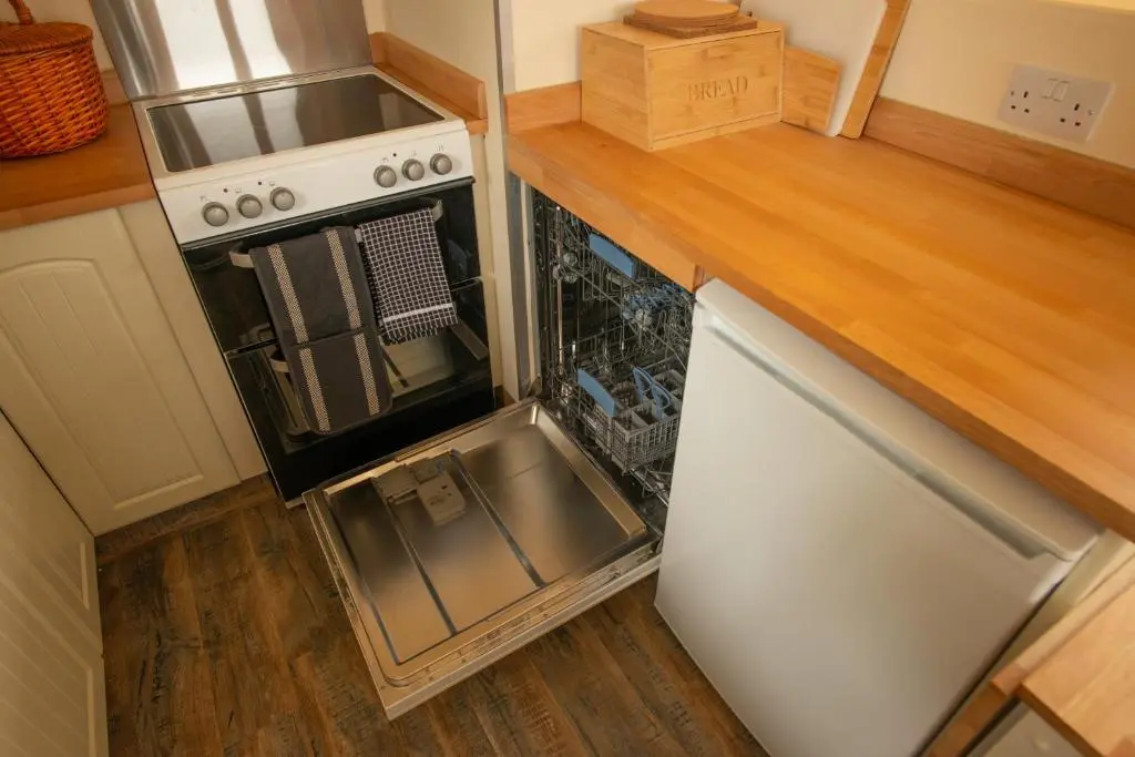 a small kitchen with a stove and a refrigerator at The High Croft in Rogart