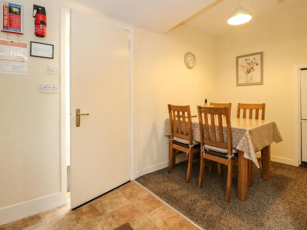 a dining room with a table and chairs at Rose Cottage in Strathpeffer