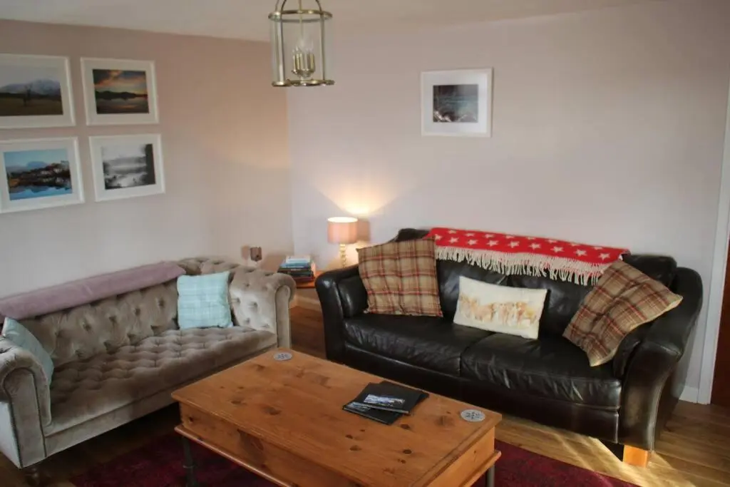 a living room with a couch and a coffee table at Upper Corronich in Boat of Garten