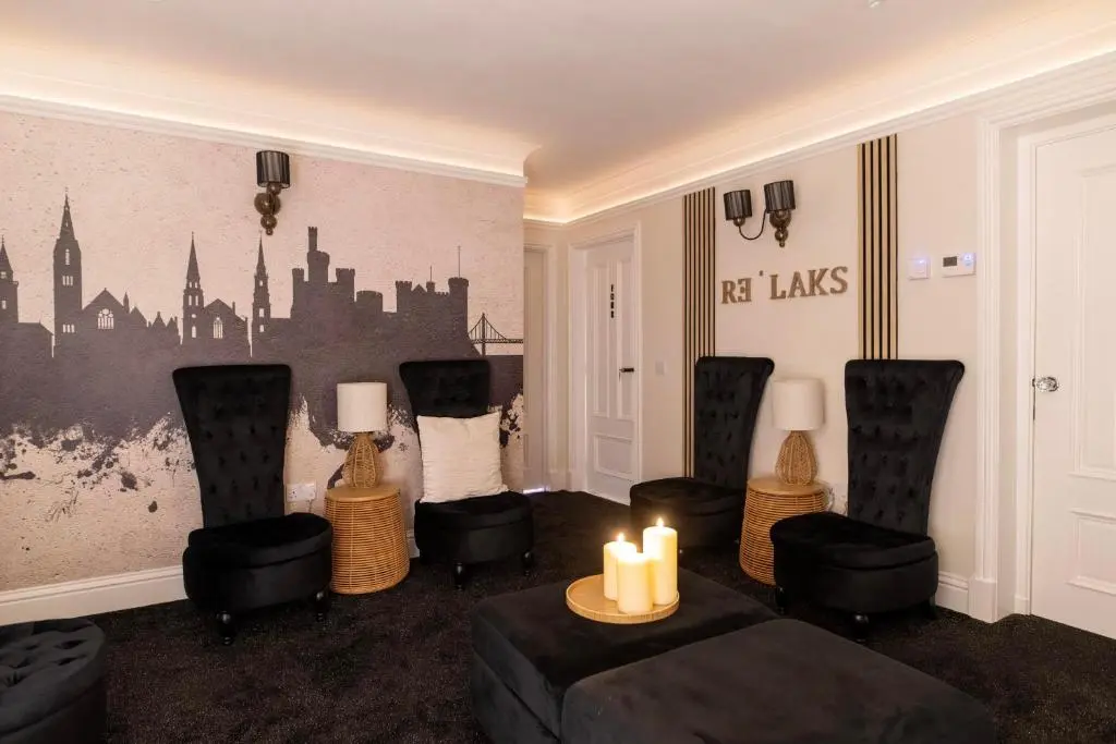 a living room with chairs and candles on the wall at The Koko Rooms in Inverness