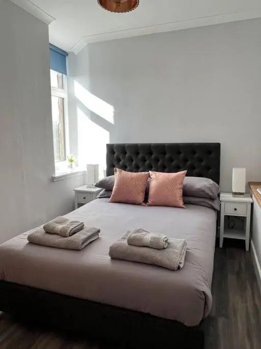 a bedroom with a large bed with two pillows on it at Kingsmills Apartment in Inverness