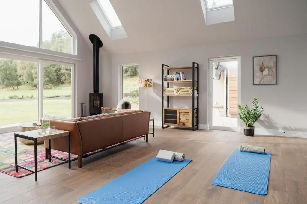 a living room with a couch and two blue mats at Culfoichbeg Lodge - Seasgair Lodges in Grantown on Spey