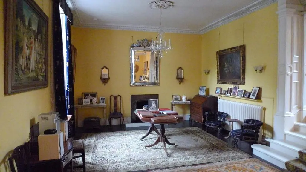a living room with a table and a fireplace at Thrumster House in Wick