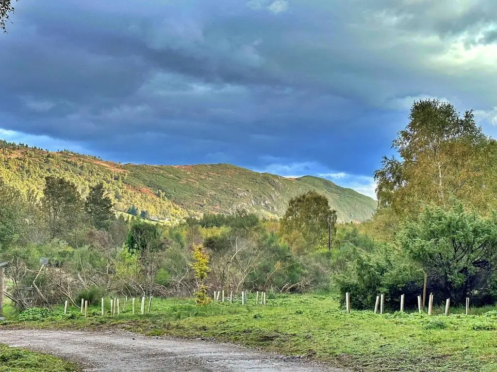 a dirt road in a field with mountains in the background at Finest Retreats - Cosagach Falls Cabin in Kiltarlty