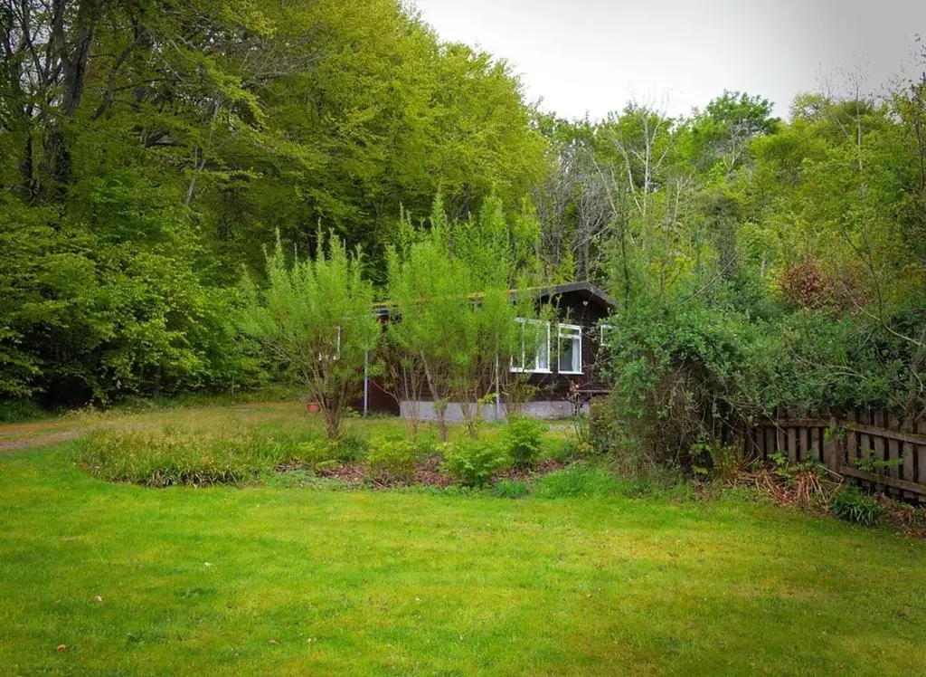 a small house in the middle of a yard at Baillie Chalet on Reelig Estate in Kirkhill