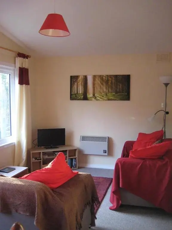 a bedroom with two beds with red pillows at Satchwell Chalet on Reelig Estate - Dog Friendly in Kirkhill
