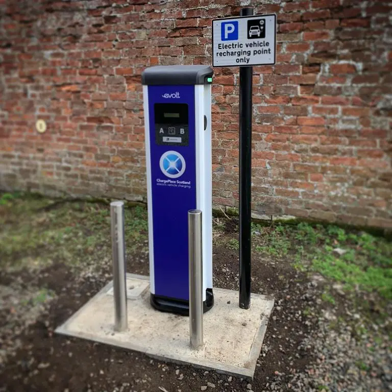 a blue parking meter sitting next to a brick wall at The Malt Van - Beautiful, luxury static caravan in Aberlour