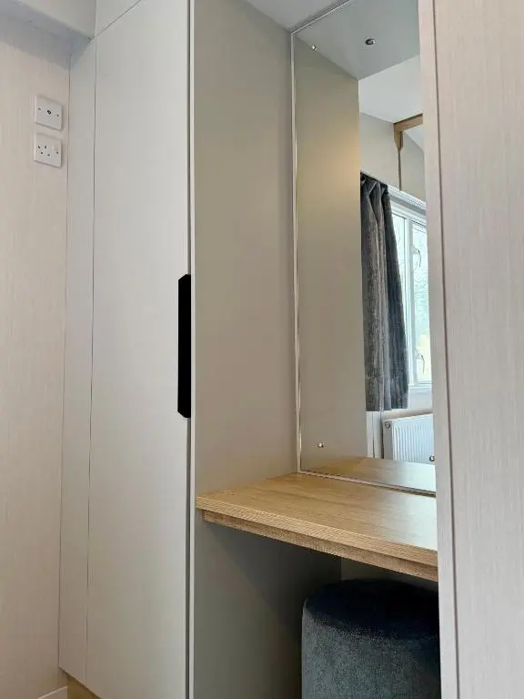 a small room with a desk and a mirror at The Ghillie's Van - Beautiful, luxury static caravan in Aberlour