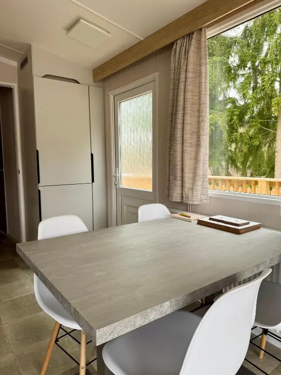 a kitchen with a table and chairs and a window at The Ghillie's Van - Beautiful, luxury static caravan in Aberlour