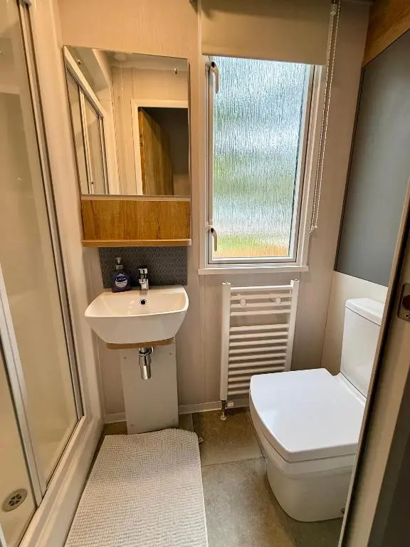 a small bathroom with a toilet and a sink at The Cooper's Van - Beautiful, luxury static caravan in Aberlour