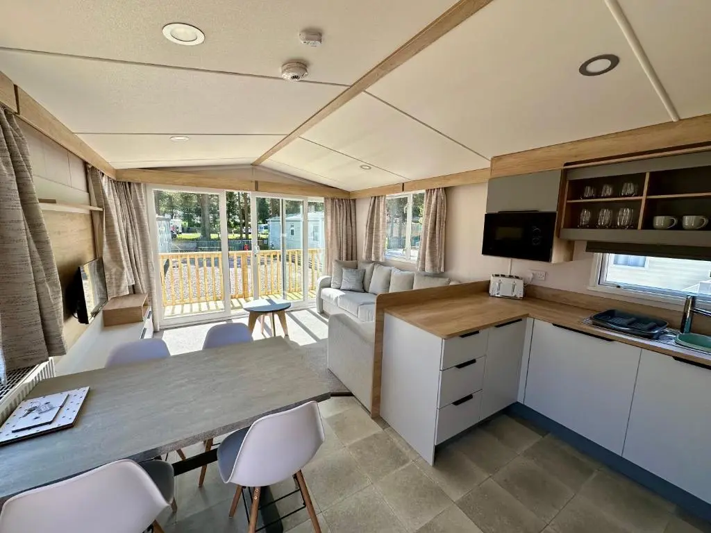 a caravan kitchen and living room with a table and chairs at The Distiller\u2019s Van - Beautiful, luxury static caravan in Aberlour