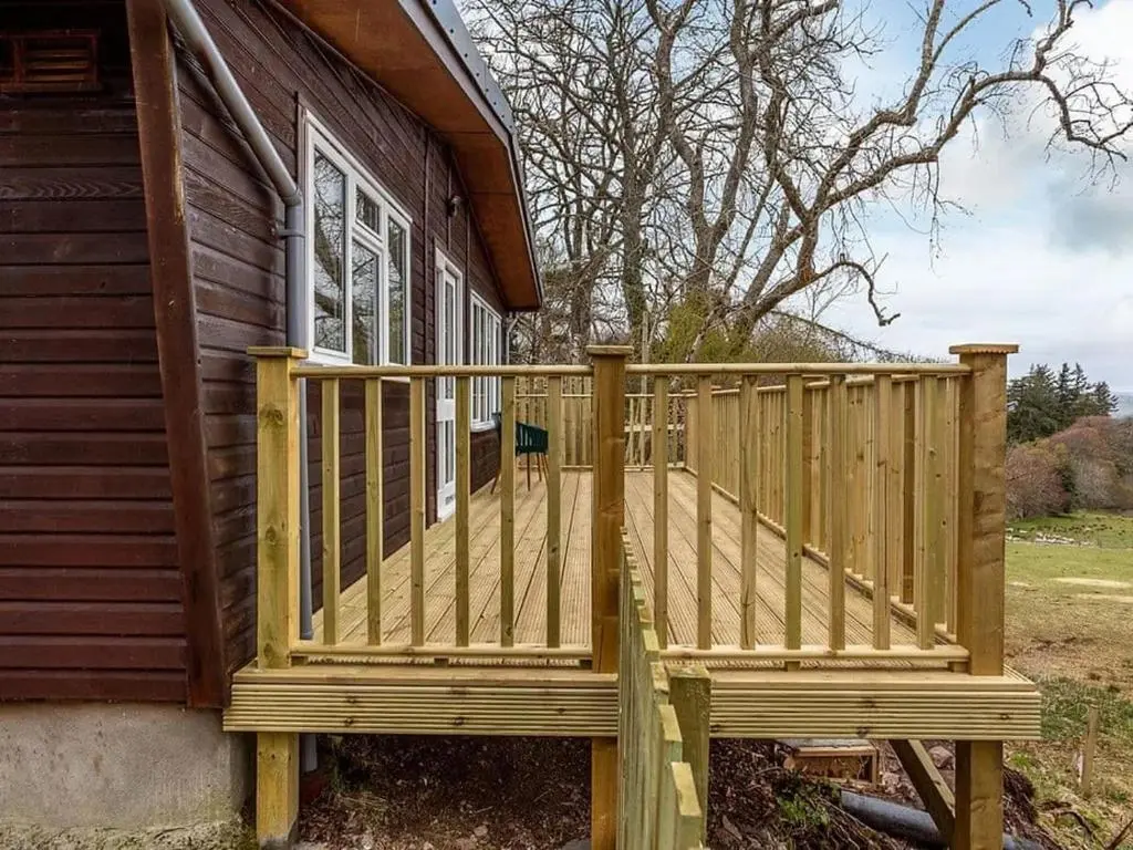 a wooden deck on the side of a house at Kilninver Chalet on Reelig Estate in Kirkhill