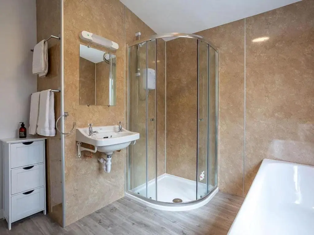 a bathroom with a glass shower and a sink at Kilninver Chalet on Reelig Estate in Kirkhill