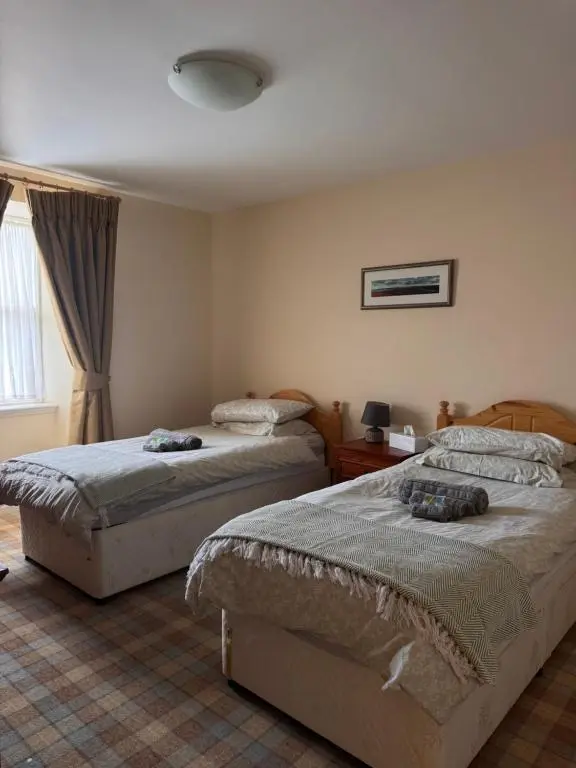 a bedroom with two beds and a window at Craiglea Lodge in Latheron