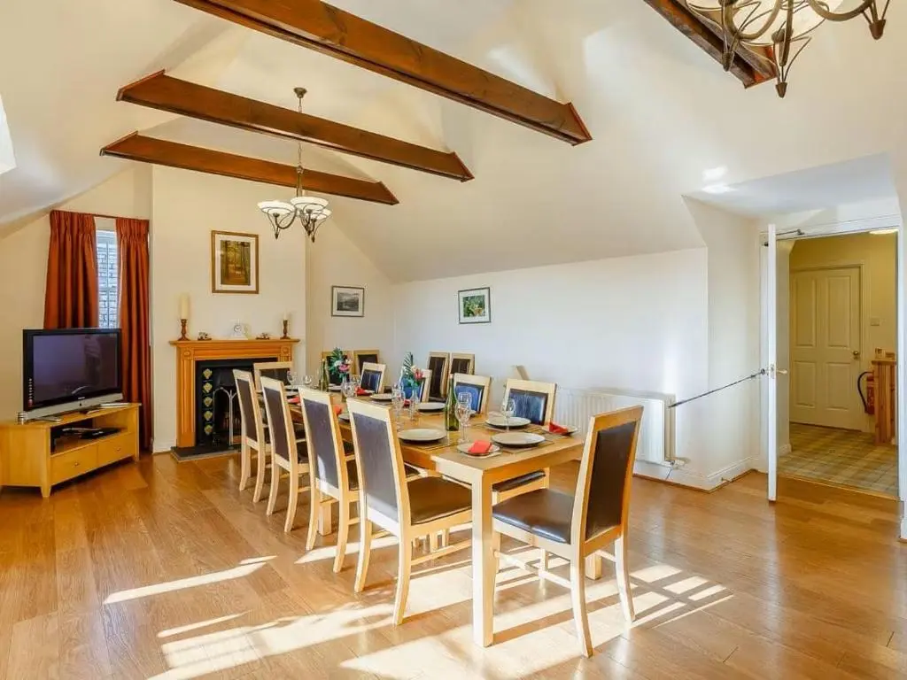 a dining room with a table and chairs and a television at Craiglea Lodge in Latheron