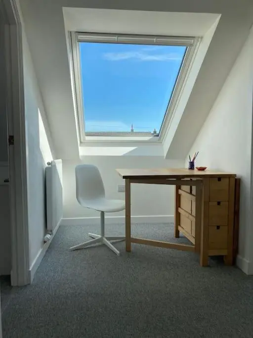 a desk and a chair in a room with a window at 3-Bedroom Eco-house with EV charger. in Rosemarkie