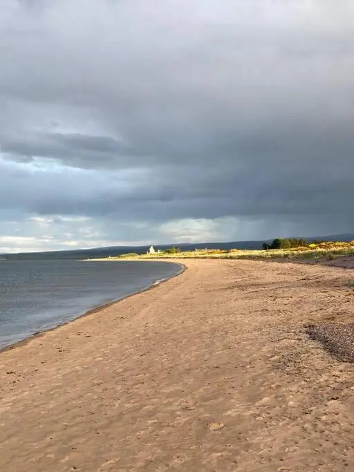 a sandy beach with the ocean in the background at 3-Bedroom Eco-house with EV charger. in Rosemarkie