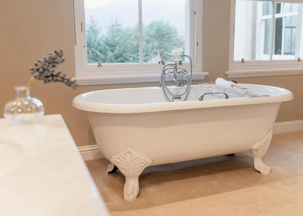 a white bath tub in a bathroom with a window at Milton Lodge - Seasgair Lodges in Newtonmore