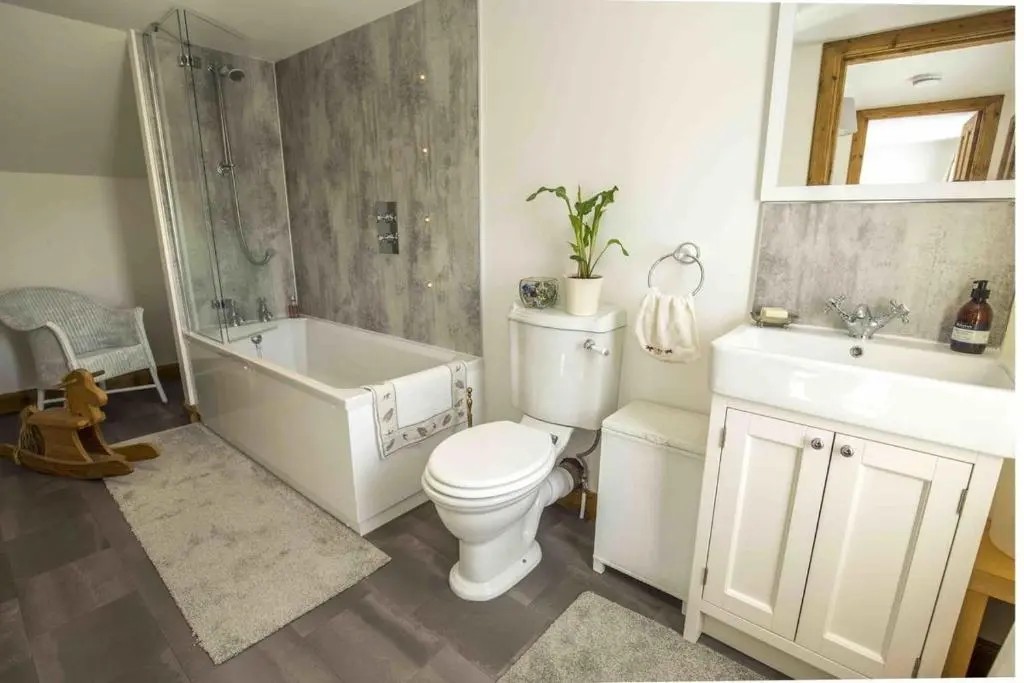 a bathroom with a toilet and a tub and a sink at Douglas Cottage - Seasgair Lodges in Boat of Garten