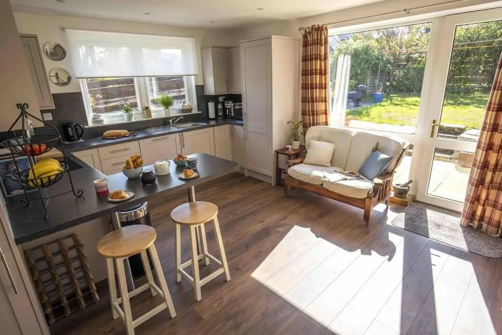 a kitchen and living room with a couch and a table at Douglas Cottage - Seasgair Lodges in Boat of Garten