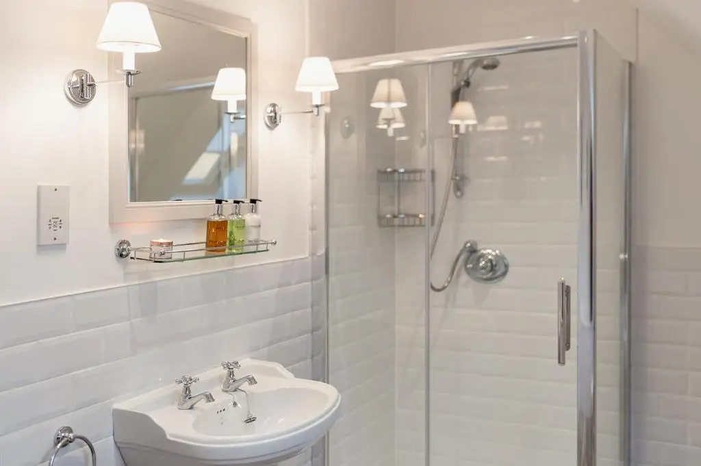a white bathroom with a sink and a shower at Oak Cottage - Seasgair Lodges in Kincraig
