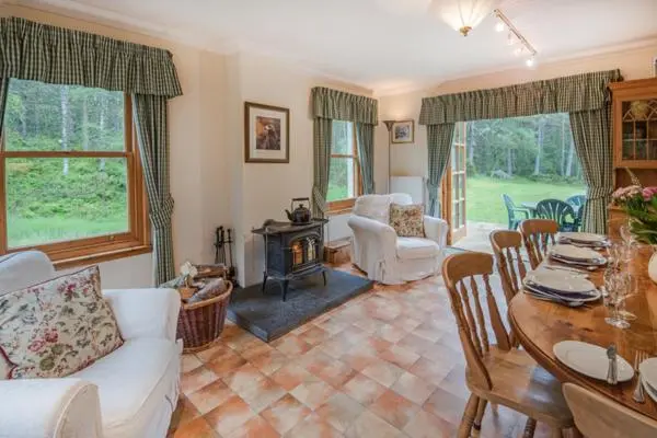 a living room with a white couch and a table at Rymore Wood Lodge - Seasgair Lodges in Nethy Bridge
