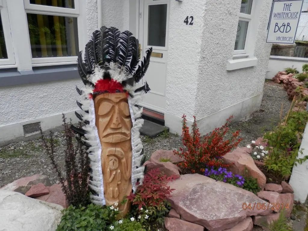 a statue in a garden in front of a house at The Whitehouse in Dingwall