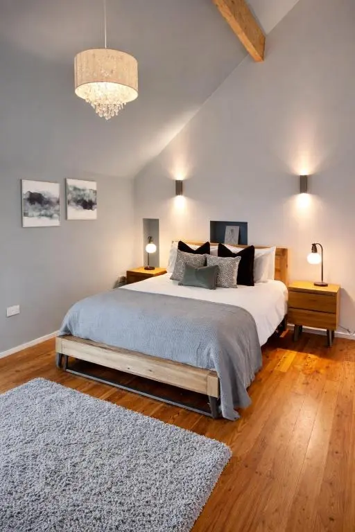 a bedroom with a large bed and a chandelier at The Highland MoonRay in Inverness