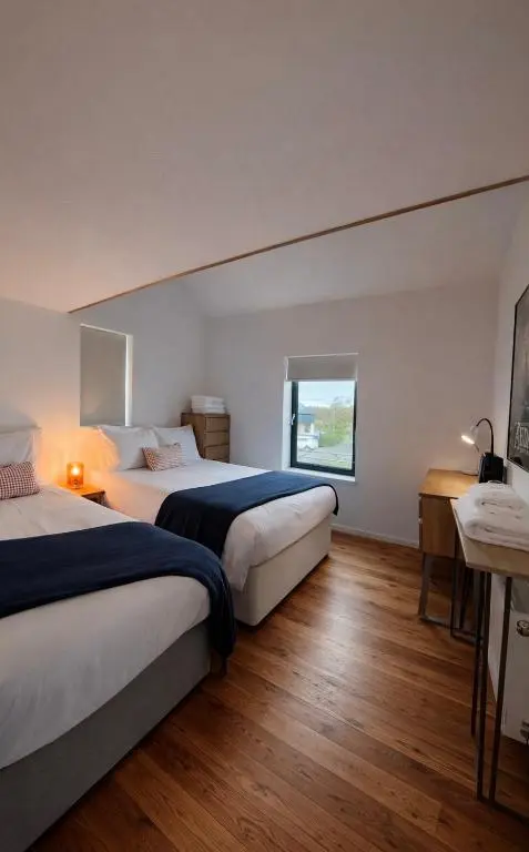 a hotel room with two beds and a window at The Highland MoonRay in Inverness