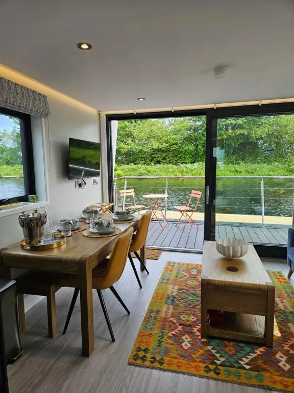 a dining room with a table and chairs and a balcony at Caley Cruisers in Inverness
