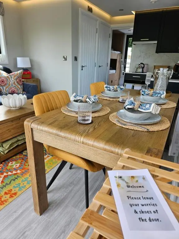 a wooden table with plates and dishes on it in a living room at Caley Cruisers in Inverness