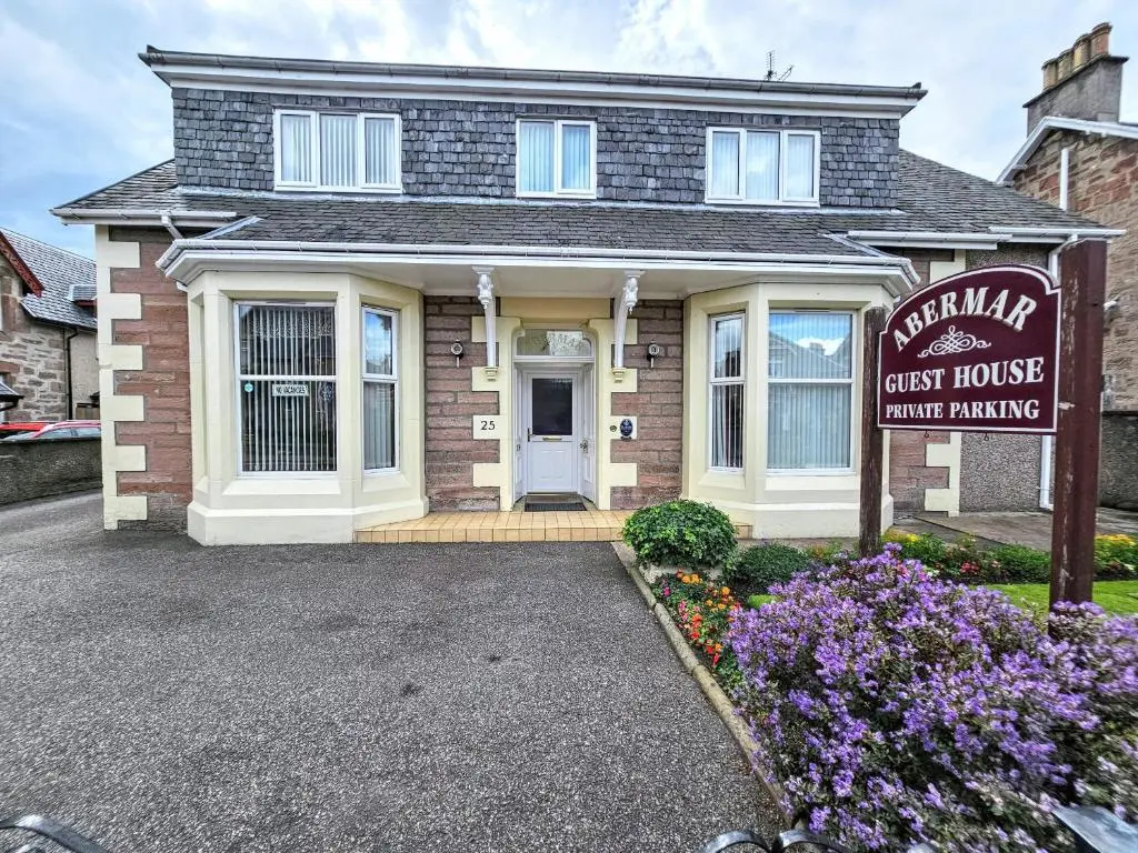 a house with a sign in front of it at mySTAYINN Abermar 12 Bedroom House in Inverness