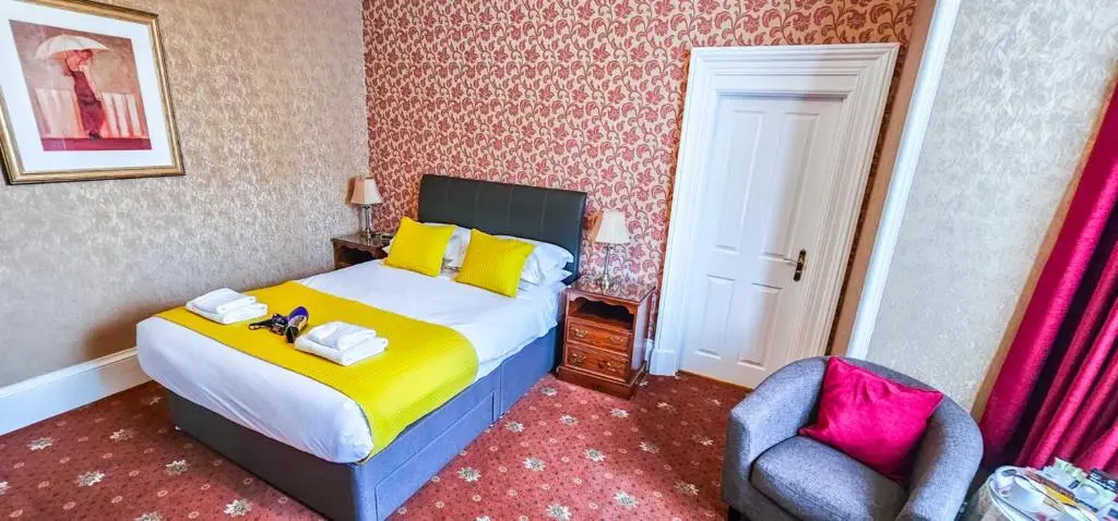a bedroom with a bed and a chair at mySTAYINN Abermar Guest House in Inverness