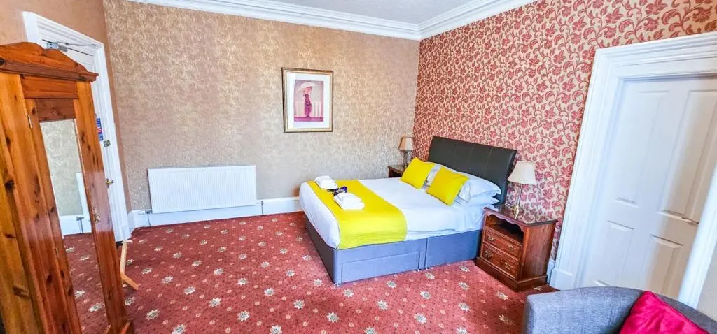 a bedroom with a bed with yellow pillows at mySTAYINN Abermar Guest House in Inverness
