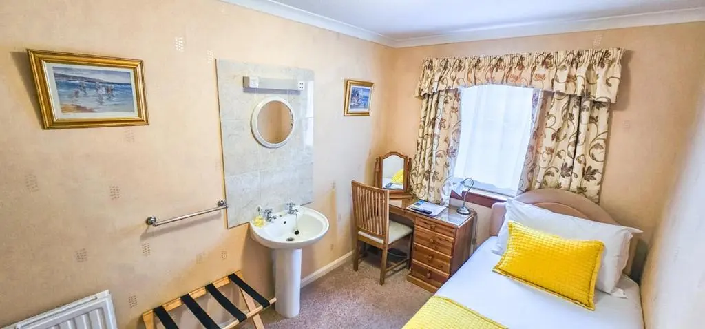 a small bathroom with a bed and a sink at mySTAYINN Abermar Guest House in Inverness