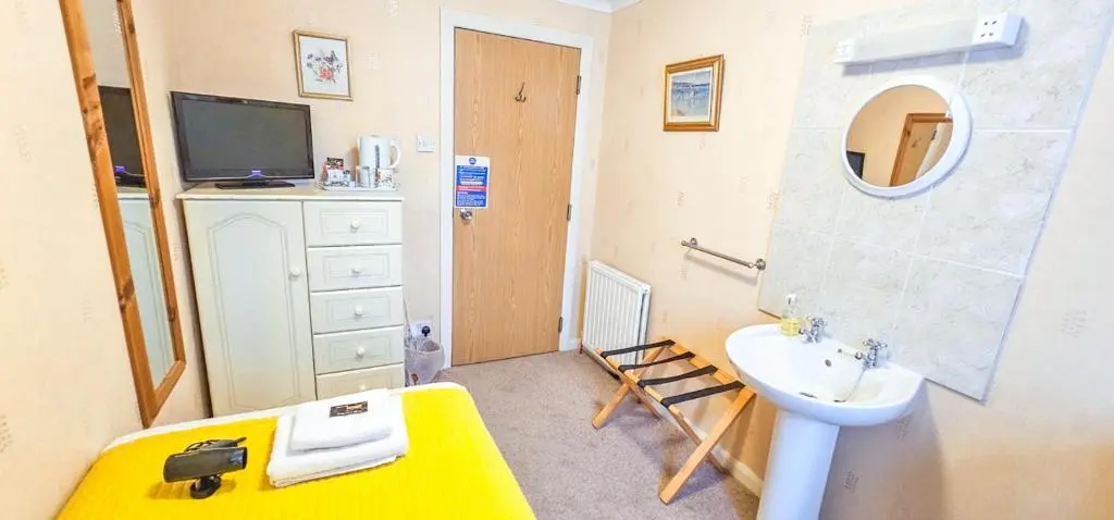 a bathroom with a sink and a toilet and a mirror at mySTAYINN Abermar Guest House in Inverness
