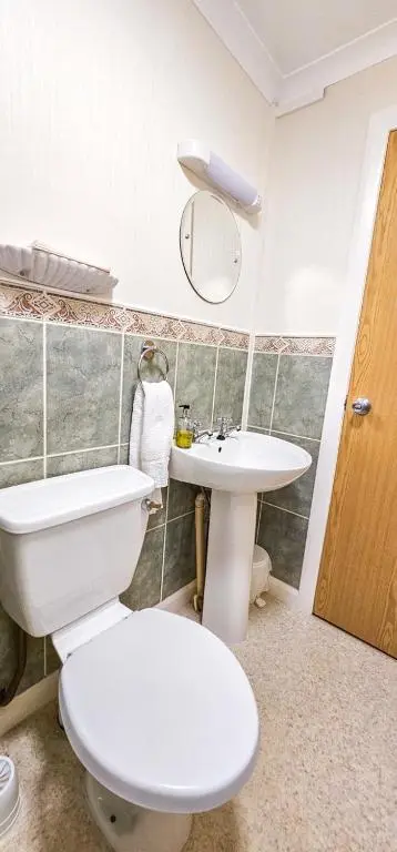 a bathroom with a white toilet and a sink at mySTAYINN Abermar Guest House in Inverness