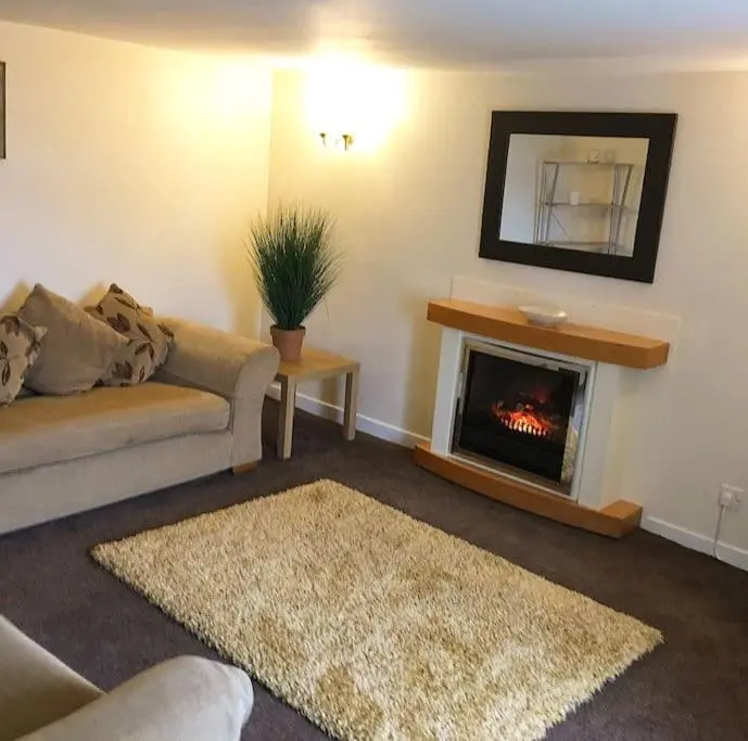 a living room with a couch and a fireplace at Traditional Croft Cottage Minutes from Lochness in Drumnadrochit