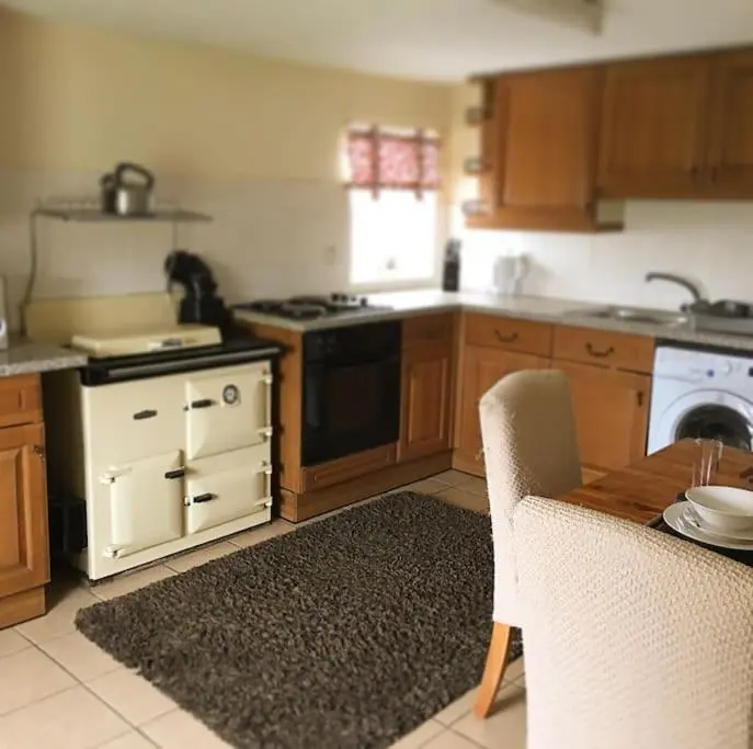 a kitchen with a table and a stove top oven at Traditional Croft Cottage Minutes from Lochness in Drumnadrochit