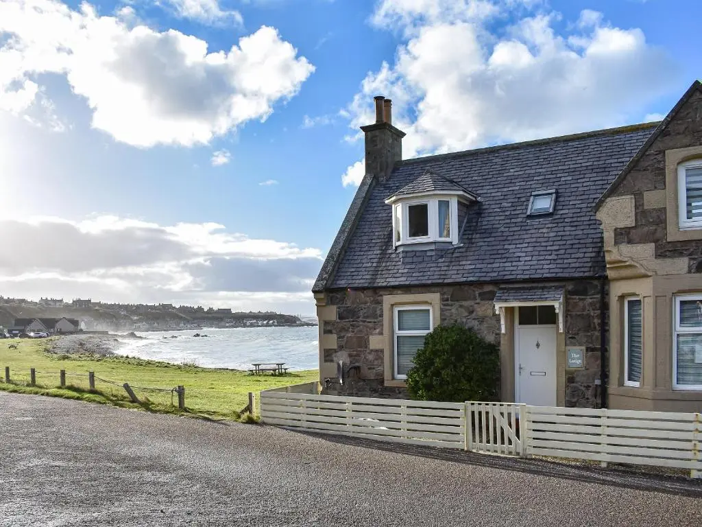 a stone house on the shore of the ocean at Strathlene Lodge in Ianstown