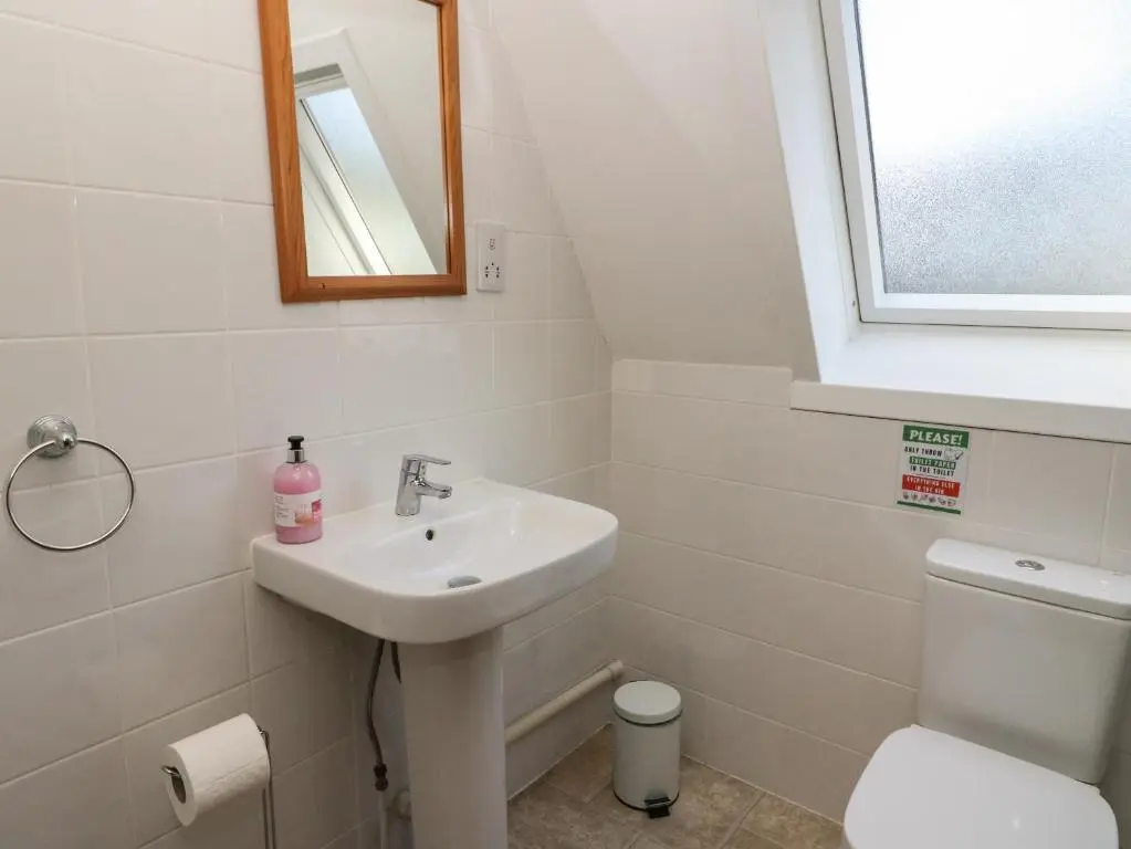 a bathroom with a sink and a toilet and a mirror at 27 Invergarry Lodges in Spean Bridge