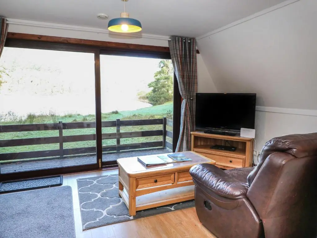 a living room with a couch and a television at 27 Invergarry Lodges in Spean Bridge