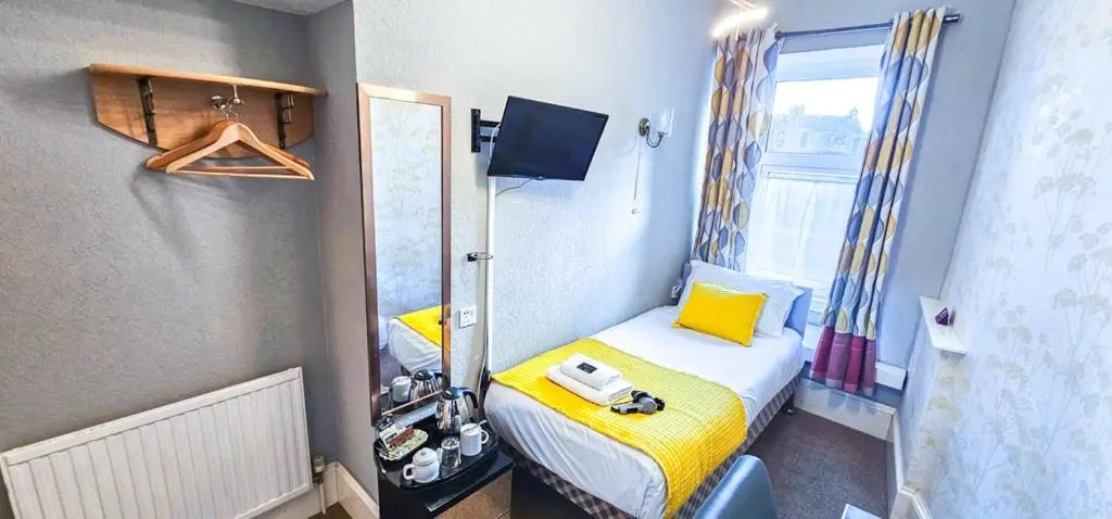 a small room with a bed and a window at mySTAYINN Kinloch 7 Bedroom House in Inverness