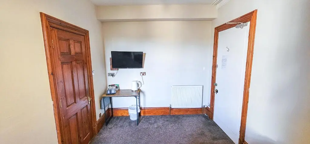 a room with a door and a table and a television at mySTAYINN Melrose Villa in Inverness