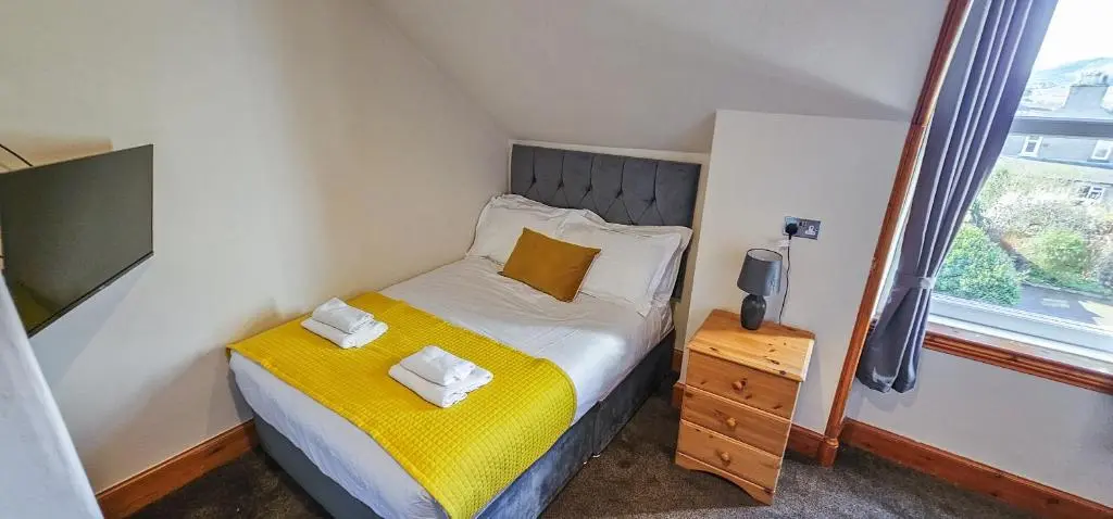 a small bedroom with a bed and a window at mySTAYINN Melrose Villa in Inverness