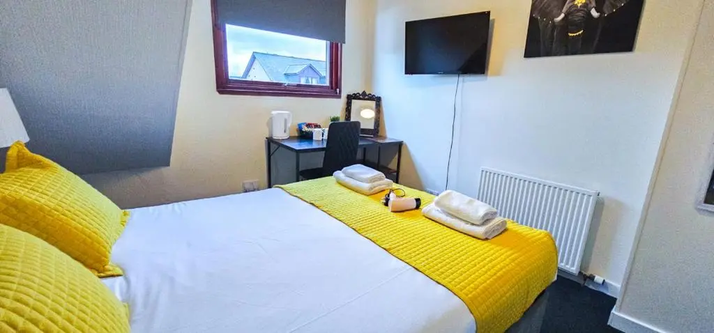 a bedroom with a bed with two towels on it at mySTAYINN Telford Guest House in Inverness